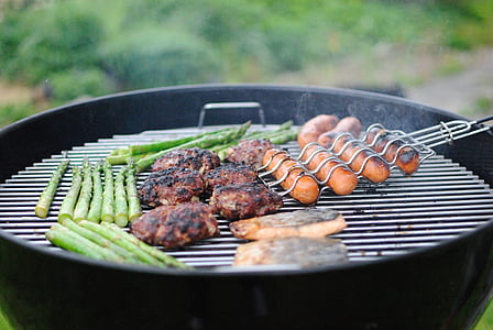 Weber kettle with meat and veggies cooking on its grate